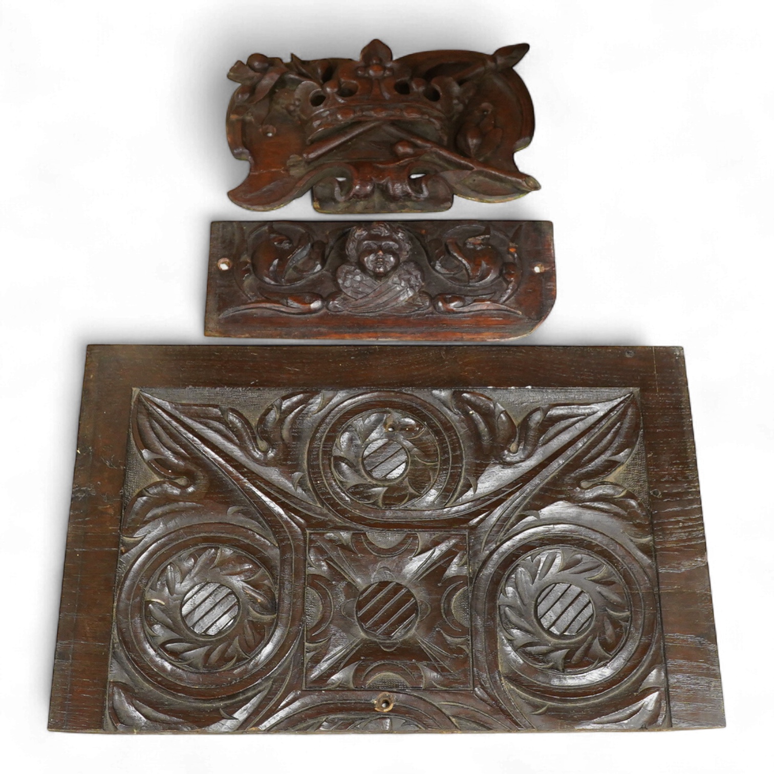 Three 18th century and later carved oak panels, one carved with a coronet, largest 46cm wide